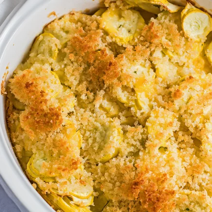 casserole dish with yellow squash casserole covered in crunchy golden panko